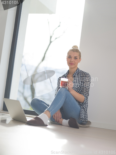 Image of young woman drinking coffee enjoying relaxing lifestyle