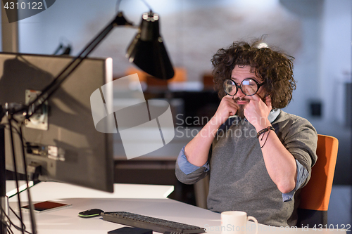 Image of man working on computer in dark startup office