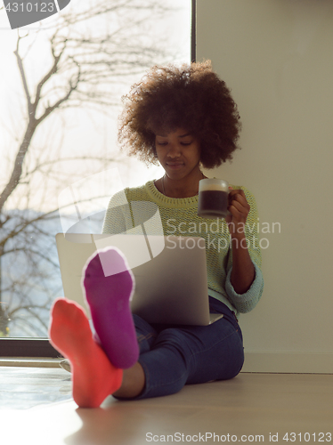 Image of black woman in the living room on the floor