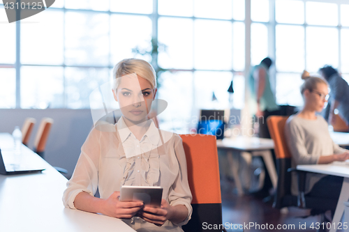 Image of woman working on digital tablet in night office