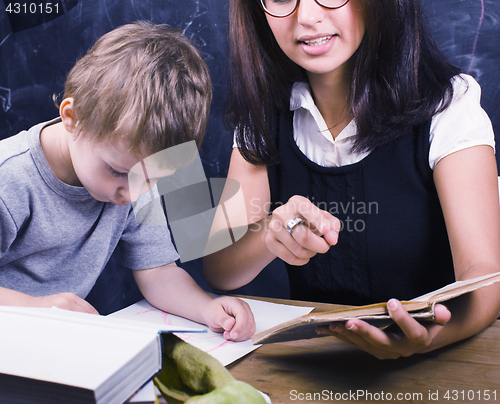 Image of little cute boy with teacher in classroom