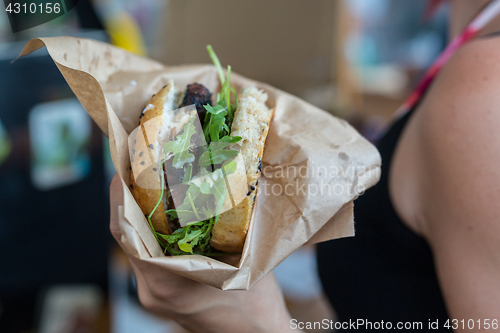 Image of Woman holding juicy burger in her hands.