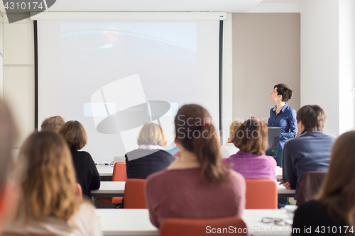 Image of Woman giving presentation in lecture hall at university.