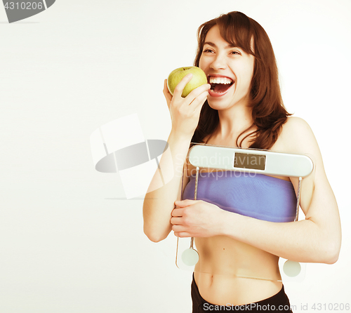 Image of portrait of young smiling girl with green apple and scales