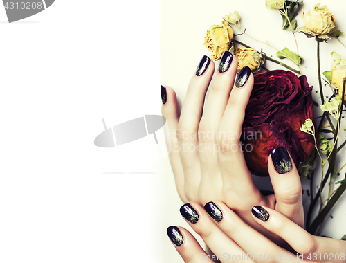 Image of close up picture of manicure nails with dry flower red rose