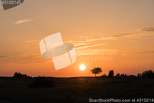 Image of Colorful sunset by a plain grassland 