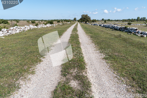 Image of Straight country road surrounded with stone walls