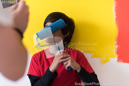 Image of young boy painter with paint roller