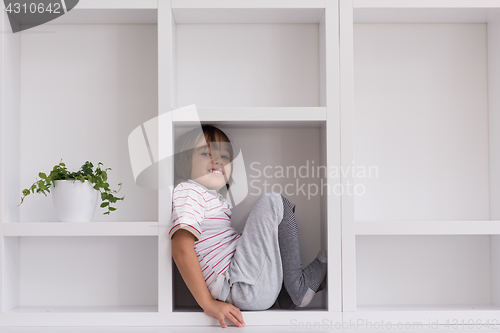 Image of young boy posing on a shelf