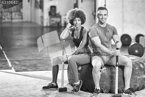 Image of multiethnic couple after workout with hammer