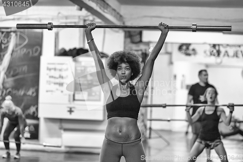 Image of black woman lifting empty bar