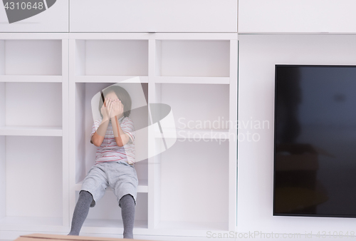 Image of young boy posing on a shelf