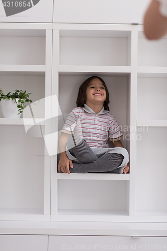 Image of young boy posing on a shelf