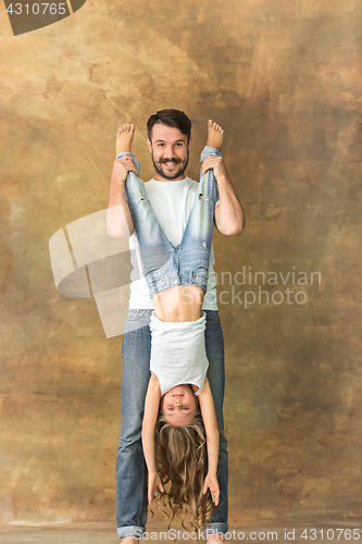 Image of Man hugging her teenage daughter at brown