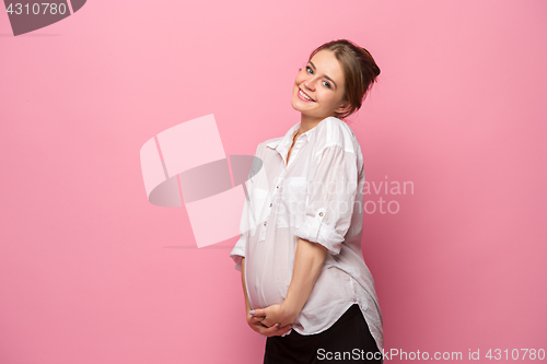 Image of Young beautiful pregnant woman standing on pink background