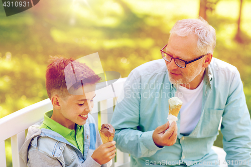 Image of old man and boy eating ice cream at summer park