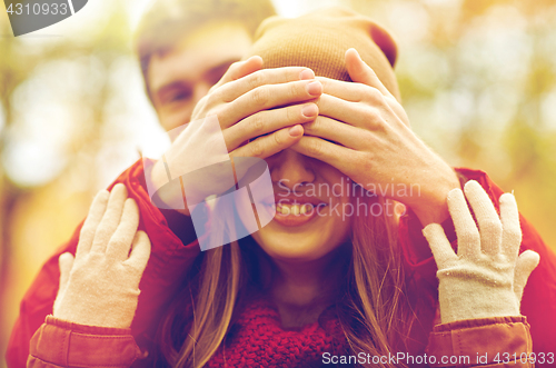 Image of happy young couple having fun in autumn park