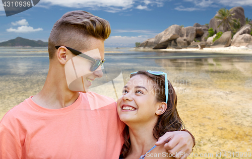 Image of happy teenage couple hugging at summer beach