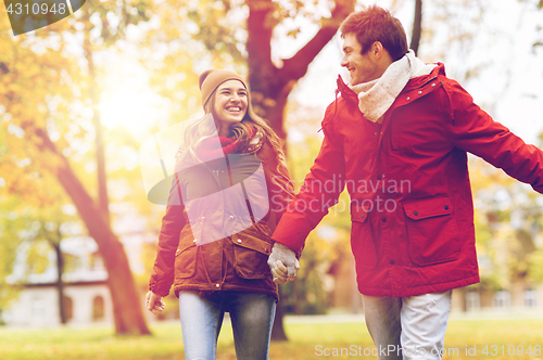 Image of happy young couple walking in autumn park