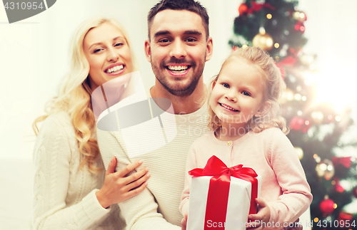 Image of happy family at home with christmas gift box