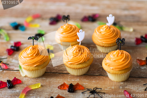 Image of halloween party decorated cupcakes on wooden table