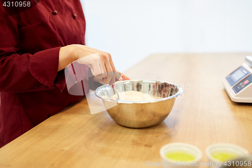 Image of chef with flour in bowl making batter or dough