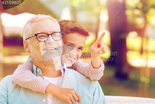 Image of grandfather and boy pointing finger at summer park