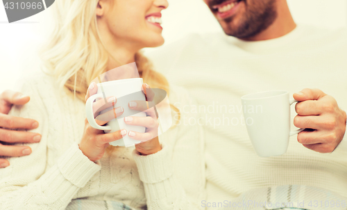 Image of close up of happy couple with tea cups at home