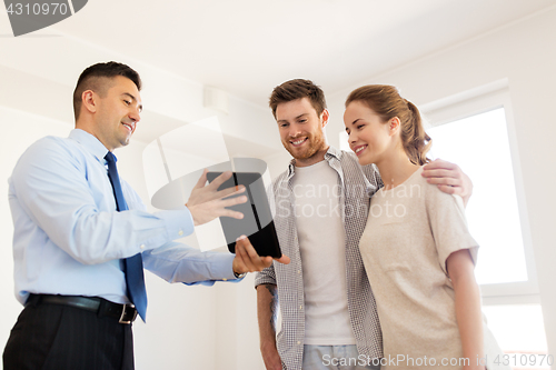 Image of couple and realtor with tablet pc at new home