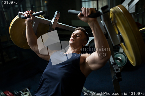 Image of man doing chest press on exercise machine in gym