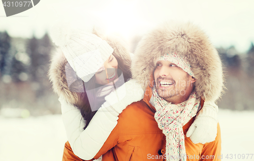 Image of happy couple having fun over winter background