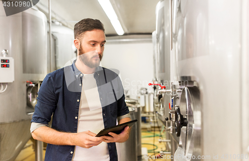 Image of man with tablet pc at craft brewery or beer plant