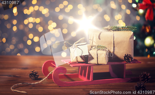 Image of close up of christmas gift boxes on wooden sleigh