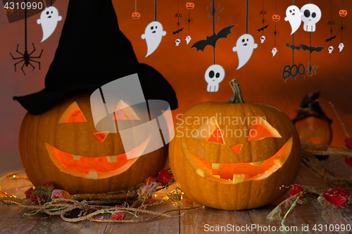 Image of carved pumpkins in witch hat and halloween garland