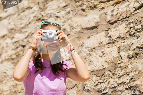 Image of teenage girl or woman with vintage camera outdoors