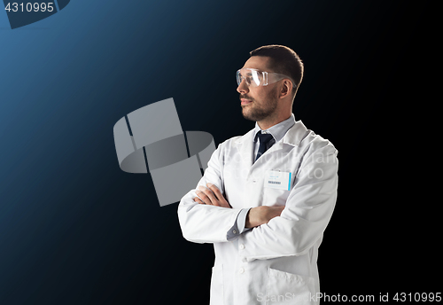 Image of scientist in lab coat and safety glasses