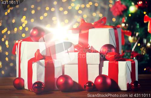 Image of gift boxes and red balls under christmas tree