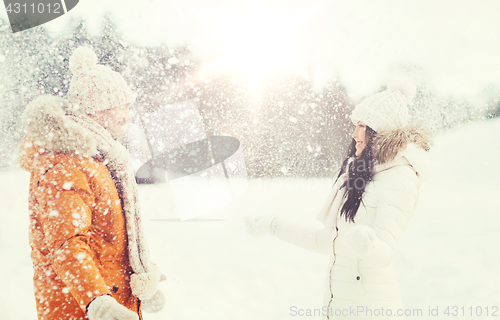 Image of happy couple playing with snow in winter