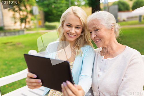 Image of daughter with tablet pc and senior mother at park