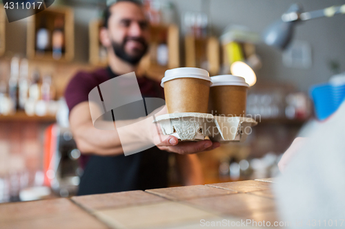 Image of man or bartender serving customer at coffee shop