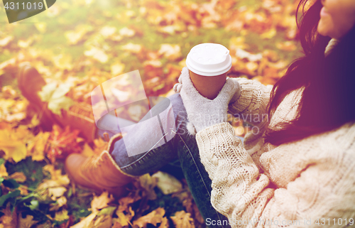 Image of close up of  woman drinking coffee in autumn park