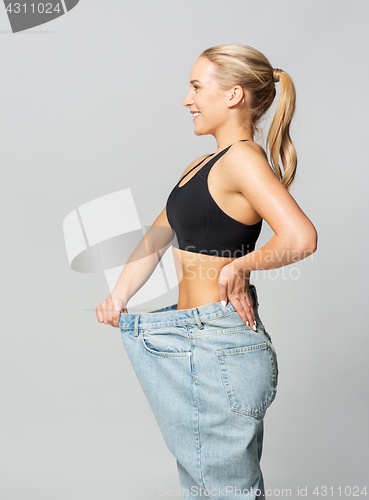 Image of young slim sporty woman in oversize pants