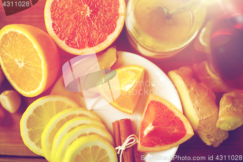 Image of ginger tea with honey, citrus and garlic on wood