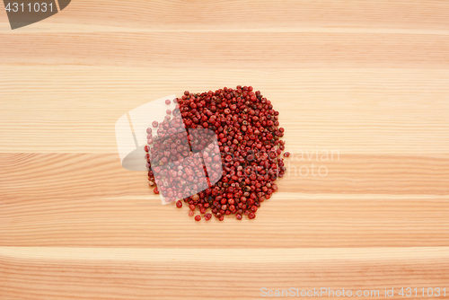 Image of Pink peppercorns on wood