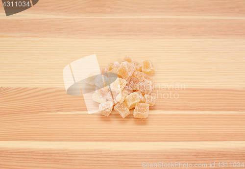 Image of Cubes of crystallised stem ginger on wood