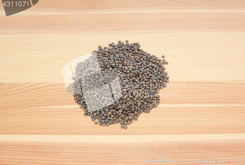 Image of Marbled dark green lentils on wood