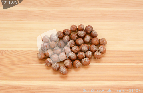 Image of Hazelnuts in shells on wood