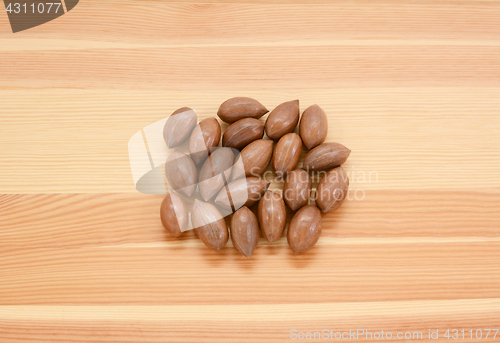 Image of Pecan nuts in shells on wood