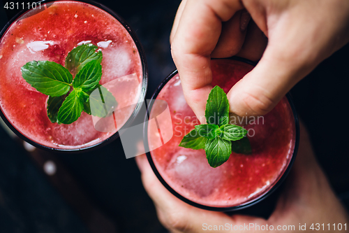 Image of Person decorates red smoothie