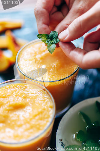 Image of Person decorates orange smoothie